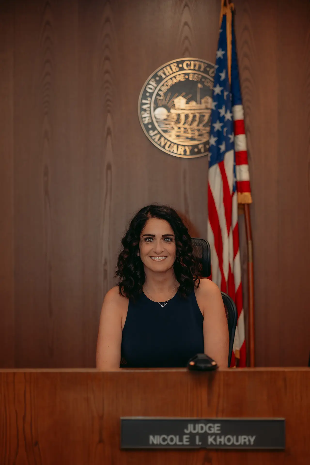 Judge Khoury seated at the bench behind her nameplate