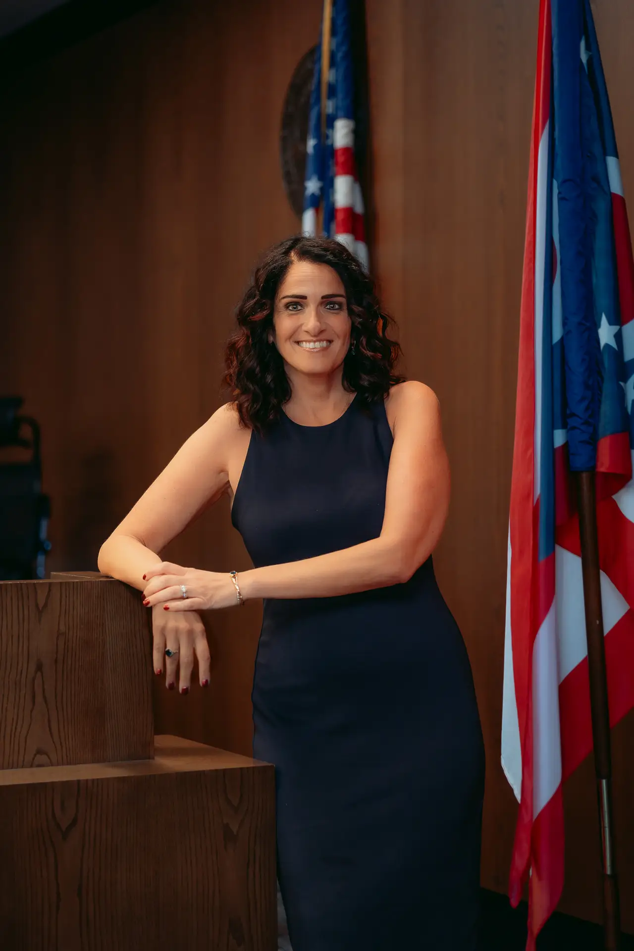 Judge Nicole Khoury standing beside the American and Ohio flags in her courtroom